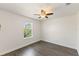 Bedroom with hardwood floors, ceiling fan, and window overlooking greenery at 7816 Winter Wren St, Winter Garden, FL 34787