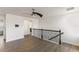 Bright hallway features a ceiling fan, hardwood floors, and staircase with decorative wrought iron banister at 7816 Winter Wren St, Winter Garden, FL 34787