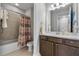 Bathroom featuring a bathtub, tiled wall, shower curtain, and a wooden vanity with light countertop at 8427 Modiano St, Orlando, FL 32827