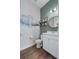 This bathroom features a modern vanity, wood-look floors, decorative shelving and tasteful wall art at 8427 Modiano St, Orlando, FL 32827