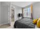 Inviting bedroom features a cozy bed with yellow accents and a window with orange tint curtains at 8427 Modiano St, Orlando, FL 32827