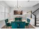 Stylish dining room with elegant velvet chairs, modern lighting, and staircase access at 8427 Modiano St, Orlando, FL 32827
