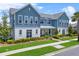 Charming two-story blue and white home featuring a well-manicured lawn and inviting front porch at 8427 Modiano St, Orlando, FL 32827