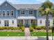 Inviting blue and white two-story home with a well-manicured lawn, walkway, and beautiful landscaping at 8427 Modiano St, Orlando, FL 32827