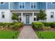 Welcoming front entrance with a brick pathway, lush landscaping, and a stylish blue front door at 8427 Modiano St, Orlando, FL 32827