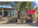 Picturesque outdoor dining area, shaded by mature trees and umbrellas, offers inviting seating arrangements at 8427 Modiano St, Orlando, FL 32827