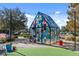 Stained glass house sculpture under strung lights sits on artificial turf within a lushly landscaped community park at 8427 Modiano St, Orlando, FL 32827