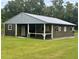 Exterior view of the barn with multiple stalls, paddocks, and grassy surroundings at 2508 Fawn Run, Oviedo, FL 32765