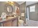 Bathroom featuring a wood vanity, granite counters, a decorative mirror, and a tub shower combo at 2508 Fawn Run, Oviedo, FL 32765