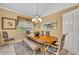 Formal dining room with wood table, bench, chairs, chandelier, and large window at 2508 Fawn Run, Oviedo, FL 32765