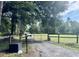 Gated entrance to the estate showing a gravel driveway and wooded surroundings at 2508 Fawn Run, Oviedo, FL 32765