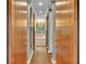 Hallway showcasing wood floors, a light fixture, and access to the main bath with barn style doors at 2508 Fawn Run, Oviedo, FL 32765