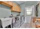 Well-lit laundry room features a utility sink and modern stainless steel washer and dryer at 2508 Fawn Run, Oviedo, FL 32765