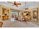 Bright living room featuring neutral furniture, a large entertainment center, and ceiling fans at 2508 Fawn Run, Oviedo, FL 32765