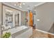 The main bath features dual sinks, granite counters, a soaking tub, a decorative shelving unit, and a barn door at 2508 Fawn Run, Oviedo, FL 32765