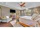 Spacious main bedroom featuring a ceiling fan, television, seating area, and access to a private outdoor patio at 2508 Fawn Run, Oviedo, FL 32765