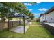 An outdoor pergola and a water well in a large green backyard with a wooden fence and white brick home at 102 Linda Ln, Lake Mary, FL 32746