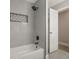 Bathroom with gray tile, white tub, black fixtures, and storage space at 102 Linda Ln, Lake Mary, FL 32746