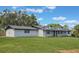 Well-maintained exterior with a white brick facade, dark trim, lush lawn, and mature trees at 102 Linda Ln, Lake Mary, FL 32746