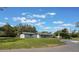 Expansive front yard featuring a well-maintained lawn, mature trees, and a paved driveway at 102 Linda Ln, Lake Mary, FL 32746