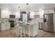 Modern kitchen featuring white cabinets, stainless steel appliances, and a stylish island with seating at 102 Linda Ln, Lake Mary, FL 32746