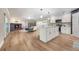 A spacious living room with wood floors, a brick fireplace and access to a modern white kitchen at 102 Linda Ln, Lake Mary, FL 32746