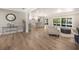 Bright, open living space with wood floors, neutral paint, and access to kitchen and outdoor patio at 102 Linda Ln, Lake Mary, FL 32746