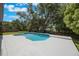 Backyard pool with a white concrete border and an expansive green yard with mature shade trees at 102 Linda Ln, Lake Mary, FL 32746