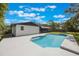 Backyard pool with a white brick house, lush green grass, and a blue sky with white clouds at 102 Linda Ln, Lake Mary, FL 32746