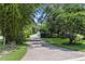Long brick driveway surrounded by bamboo and trees leads to the home's garage and entrance at 10209 Trout Rd, Orlando, FL 32836