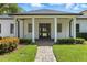 Welcoming front entrance with brick walkway, manicured landscaping and covered entry with grand white columns at 10209 Trout Rd, Orlando, FL 32836