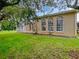 Charming home exterior featuring a screened in porch, large windows, and a well maintained lawn at 109 Greentree Ln, Yalaha, FL 34797