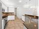 Well-lit kitchen featuring white cabinets, granite countertops, stainless appliances and tile flooring at 109 Greentree Ln, Yalaha, FL 34797