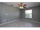Empty bedroom with ceiling fan, tile floors, grey walls and a window with bright light at 1131 S Pine Ridge Cir # 1, Sanford, FL 32773
