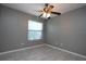 An empty bedroom with grey walls and tile floors featuring a window and ceiling fan at 1131 S Pine Ridge Cir # 1, Sanford, FL 32773