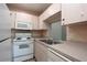 Compact kitchen with white appliances, and ample countertop space at 1131 S Pine Ridge Cir # 1, Sanford, FL 32773
