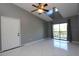 Living room with high ceilings, fan, gray walls, and sliding door to balcony at 1131 S Pine Ridge Cir # 1, Sanford, FL 32773