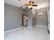 Open-concept living area with gray walls, tiled floors, and a kitchen view at 1131 S Pine Ridge Cir # 1, Sanford, FL 32773