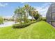 Beautiful backyard features a well manicured lawn and lake views with mature landscaping at 12286 Regal Lily Ln, Orlando, FL 32827