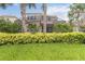 View of rear exterior of home with screened-in patio, lush landscaping, and well-manicured lawn at 12286 Regal Lily Ln, Orlando, FL 32827