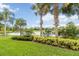 Picturesque backyard with palm trees, lush landscaping and views of the lake at 12286 Regal Lily Ln, Orlando, FL 32827