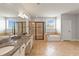 Well-lit bathroom features double sinks, granite countertops, a glass-door shower, and a soaking tub beneath a window at 12286 Regal Lily Ln, Orlando, FL 32827