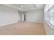 Bedroom with carpet, tray ceilings, ceiling fan, and two white doors at 12286 Regal Lily Ln, Orlando, FL 32827