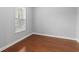 Bedroom with hardwood floors, window with blinds, and ample natural light at 12286 Regal Lily Ln, Orlando, FL 32827