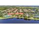 Scenic aerial view showcasing a community pool, tennis courts, and surrounding homes near a picturesque lake at 12286 Regal Lily Ln, Orlando, FL 32827