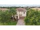 Charming two-story home with a brick driveway, tropical landscaping, and a two-car garage at 12286 Regal Lily Ln, Orlando, FL 32827