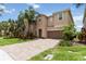 Charming two-story home with a brick driveway, well-manicured lawn, and lush landscaping at 12286 Regal Lily Ln, Orlando, FL 32827