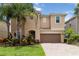 Charming two-story home with a brick driveway, well-manicured lawn and beautiful landscaping at 12286 Regal Lily Ln, Orlando, FL 32827