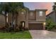 Charming two-story home with a brick driveway, well-manicured lawn and beautiful landscaping at 12286 Regal Lily Ln, Orlando, FL 32827