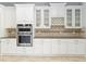 Kitchen cabinetry with glass doors, built-in oven, and granite countertops at 12286 Regal Lily Ln, Orlando, FL 32827